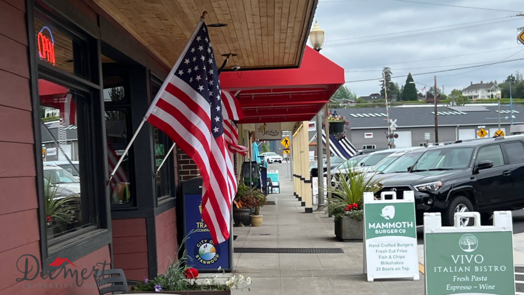A picture of Downtown Stanwood, WA with American Flags on a storefront.