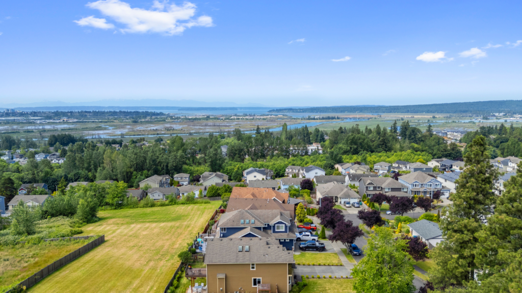 View of South Marysville, WA taken by a drone. Shows homes, the water, and the mountains.